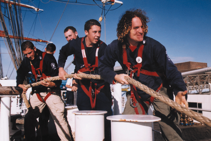 Crew on a tall ship pull on the ropes