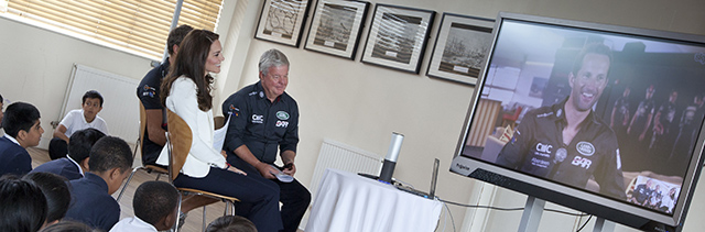 Duchess of Cambridge sits in a chair and chats to Sir Ben Ainslie via video link