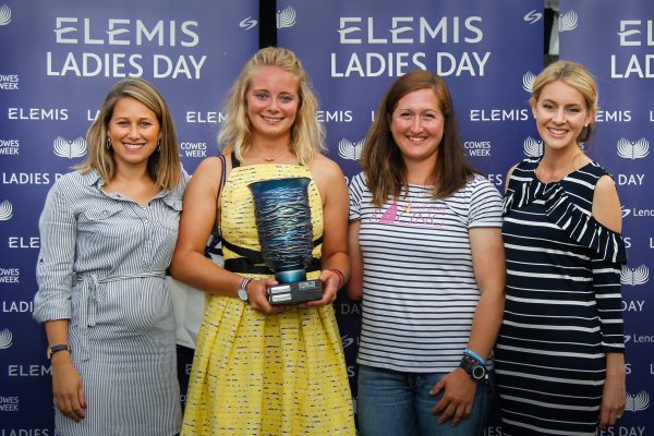 four women posing with a trophy