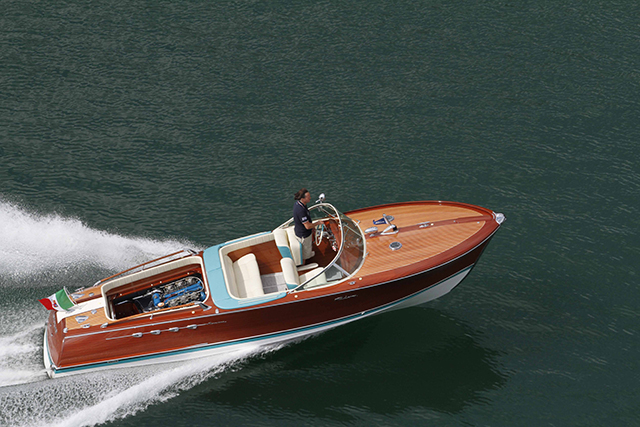 A Riva boat at full throttle on a lake