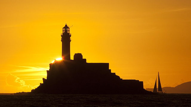 A yacht sails past the Fastnet Rock