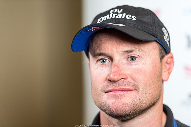 A man with stubble wearing a Fly Emirate baseball cap