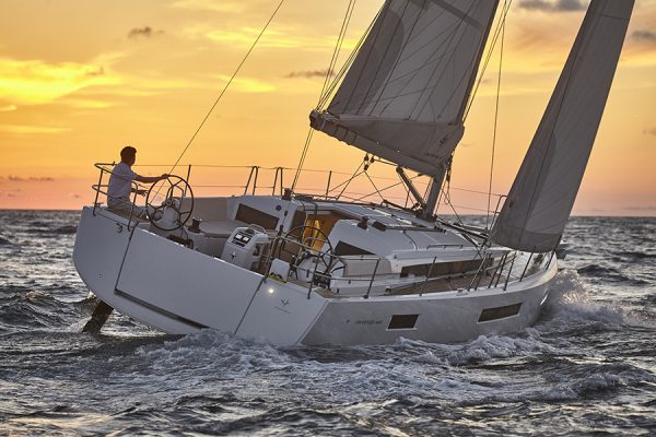 A Jenneau yacht being sailed at sunset
