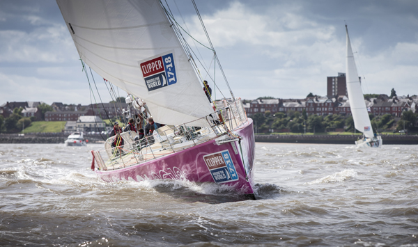 A boat with a pink hull and white sails begins the Clipper Round the World Yacht Race 2017-18