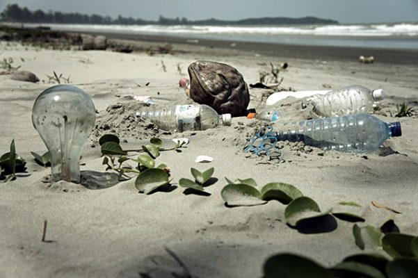 plastic bottles, glass and other rubbish pollution on a beach