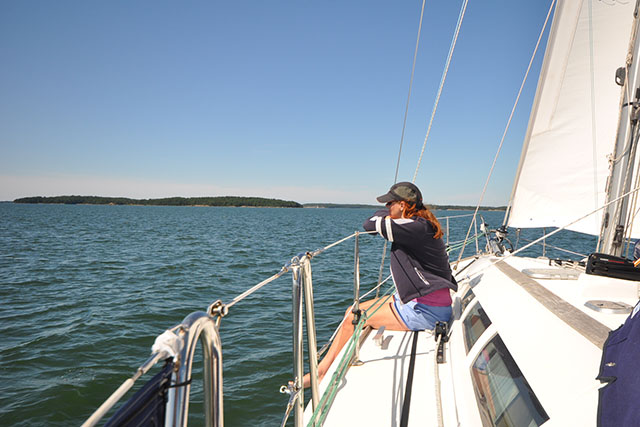 A woman sitting on the deck of a yacht with her legs over the side