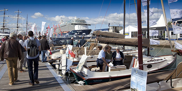 A man looking at a boat at a show