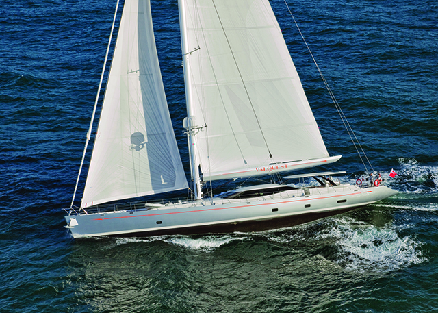A sailing superuacht with a white hull and while sails 