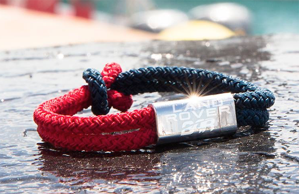 A black and red wristband with Land Rover BAR on it