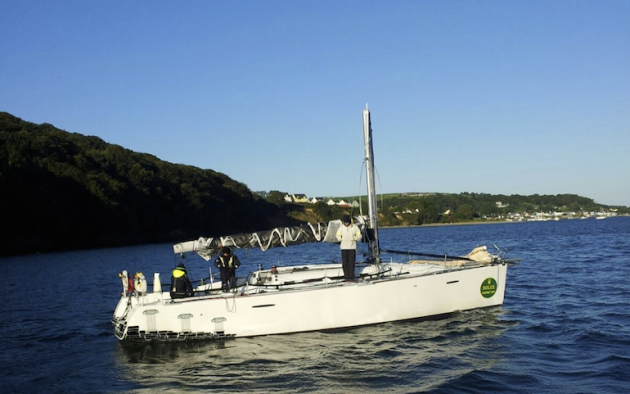 A white dismasted yacht at anchor during the Fastnet Race